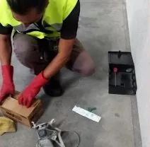 Técnico de ATRAPA-ME colocando una estación de control de plagas
