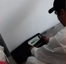 Técnico de ATRAPA-ME revisando una estación de control de plagas